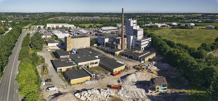 Schleswig Germany 26 June 2026 Aerial view of the former Butterwerken butter factory demolition site showing industrial buildings a tall chimney rubble and surrounding fields. Schleswig Germany 26 June 2026 Aerial view of the former Butterwerken butter factory demolition site showing industrial buildings a tall chimney rubble and surrounding fields.
