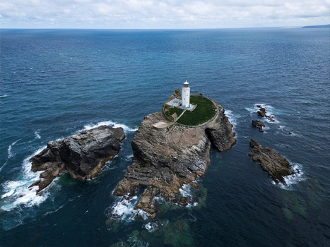 Aerial view of Godrevy Lighthouse situated on a rugged rocky island surrounded by the deep blue waters of the Atlantic Ocean in Gwithian England United Kingdom. Aerial view of Godrevy Lighthouse situated on a rugged rocky island surrounded by the deep blue waters of the Atlantic Ocean in Gwithian England United Kingdom.