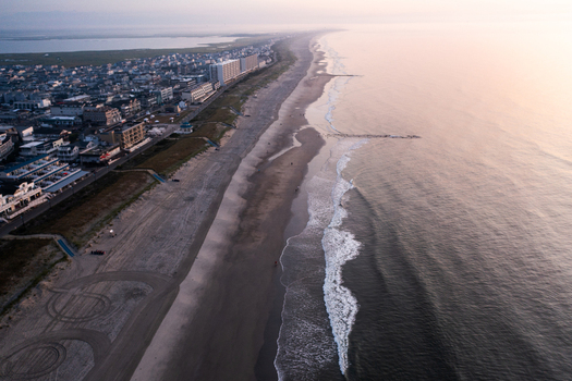 Aerial view of Sea Isle City Beach with sandy coastline gentle ocean waves and coastal buildings under soft morning light in Sea Isle City New Jersey United States. Aerial view of Sea Isle City Beach with sandy coastline gentle ocean waves and coastal buildings under soft morning light in Sea Isle City New Jersey United States.