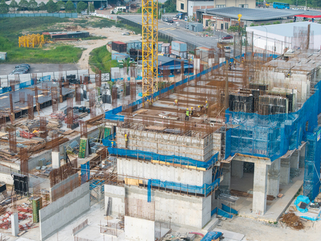 Bukit Tambun Penang Malaysia 25 September 2026 Aerial view of a construction area featuring workers a yellow crane concrete structures rebar and blue safety netting. Bukit Tambun Penang Malaysia 25 September 2026 Aerial view of a construction area featuring workers a yellow crane concrete structures rebar and blue safety netting.