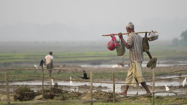 View of a man carrying supplies in rural Bogura Bangladesh.