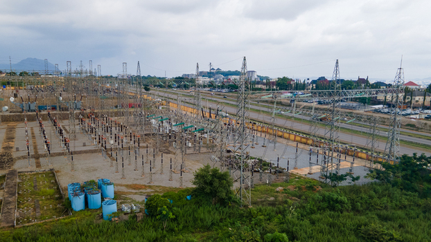 Aerial view of TCN SubStation Katampe featuring high voltage transmission towers electrical equipment and gravel grounds situated near a highway in Abuja Federal Capital Territory Nigeria.
