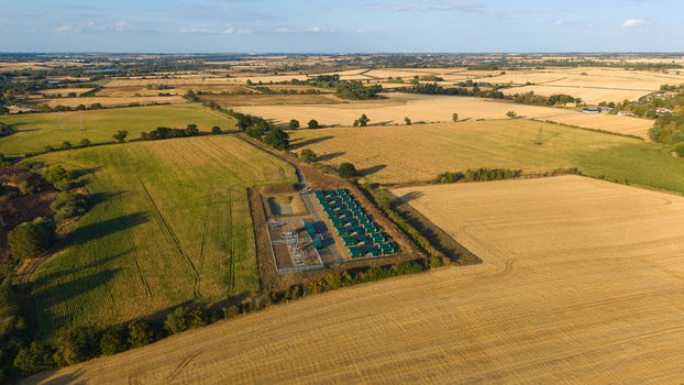 Aerial view of Battery Energy park BESS Grendon featuring rows of green battery storage containers in a rural landscape of agricultural fields in Northampton England United Kingdom. Aerial view of Battery Energy park BESS Grendon featuring rows of green battery storage containers in a rural landscape of agricultural fields in Northampton England United Kingdom.