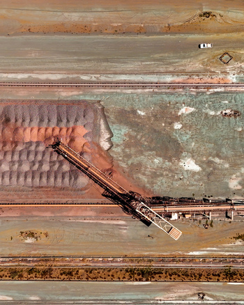 Aerial view of a large scale mining operation featuring a conveyor system loading mineral rich material into a massive stockpile in Rustenburg North West South Africa. Aerial view of a large scale mining operation featuring a conveyor system loading mineral rich material into a massive stockpile in Rustenburg North West South Africa.