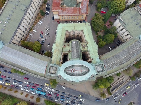 Aerial view of Sofia University St. Kliment Ohridski with its green roof surrounded by city streets parked cars and trees in Sofia Sofia City Province Bulgaria.