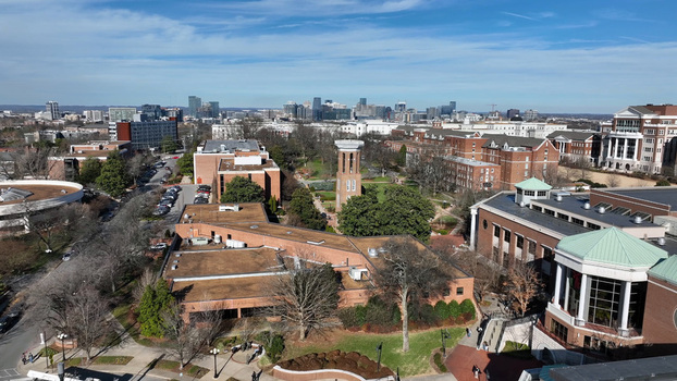 Aerial view of Vanderbilt University campus featuring the historic Kirkland Hall tower brick buildings and green lawns under a clear blue sky in Nashville Tennessee United States. Aerial view of Vanderbilt University campus featuring the historic Kirkland Hall tower brick buildings and green lawns under a clear blue sky in Nashville Tennessee United States.