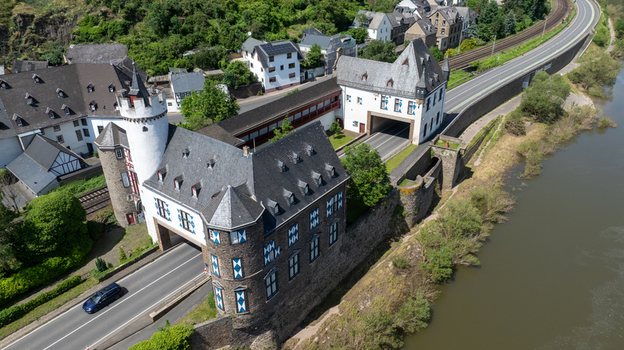 Aerial view of the historic castle complex with a main road passing through the ancient stone gatehouse and towers in Kobern Gondorf Rheinland Pfalz Germany. Aerial view of the historic castle complex with a main road passing through the ancient stone gatehouse and towers in Kobern Gondorf Rheinland Pfalz Germany.