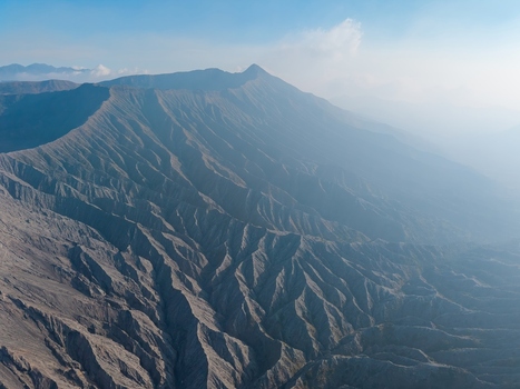 Aerial view of Mount Bromo showing the dramatic volcanic landscape with deep ridges and rugged terrain in Tosari East Java Indonesia.