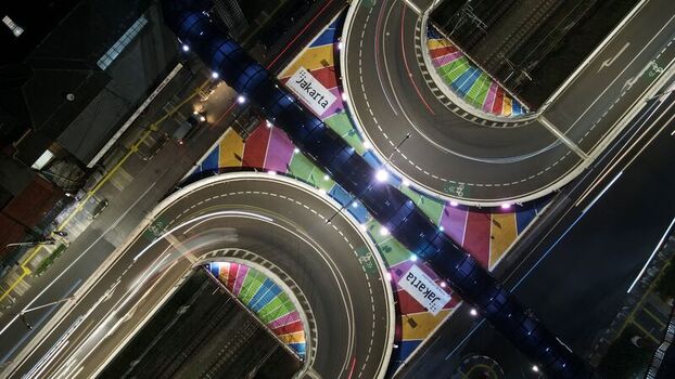 Aerial view of Flyover Tapal Kuda Jakarta with its distinctive horseshoe shape and colorful road markings illuminated at night in Pasar Minggu Daerah Khusus Ibukota Indonesia. Aerial view of Flyover Tapal Kuda Jakarta with its distinctive horseshoe shape and colorful road markings illuminated at night in Pasar Minggu Daerah Khusus Ibukota Indonesia.
