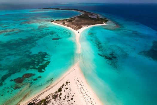 Aerial view of Los Roques archipelago featuring a narrow white sandbar extending into the turquoise Caribbean Sea Los Roques Dependencias Federale Venezuela. Aerial view of Los Roques archipelago featuring a narrow white sandbar extending into the turquoise Caribbean Sea Los Roques Dependencias Federale Venezuela.