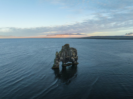 Aerial view of Hv&iacute;tserkur rock formation standing tall amidst the tranquil blue ocean under a serene sky Hvitserkur Iceland.