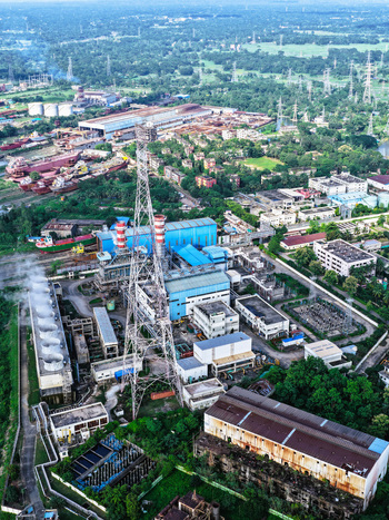 Aerial view of the industrial power plant facility with a tall communication tower and cooling units located near the Karnaphuli River in Chattogram Chittagong Division Bangladesh.