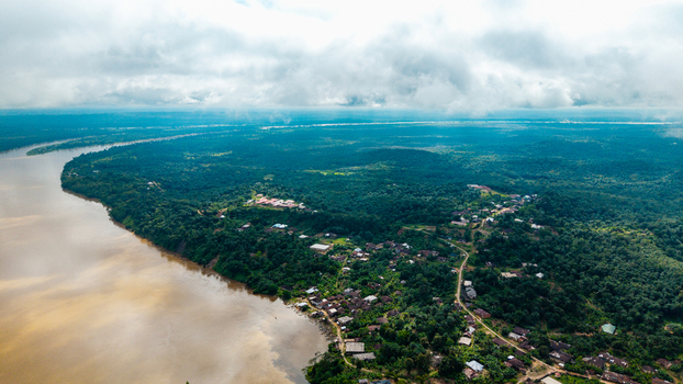 Aerial view of the Cross River winding through lush tropical forests and the town of Itu with scattered buildings and dense vegetation under a cloudy sky in Itu Akwa Ibom Nigeria. Aerial view of the Cross River winding through lush tropical forests and the town of Itu with scattered buildings and dense vegetation under a cloudy sky in Itu Akwa Ibom Nigeria.