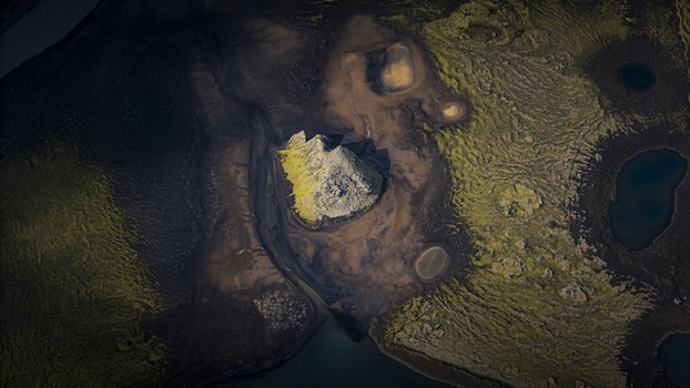 Aerial view of Langisjor lake featuring a prominent moss covered volcanic island surrounded by dark basaltic sand and rugged mossy terrain in Vik Skaftarhreppur Iceland. Aerial view of Langisjor lake featuring a prominent moss covered volcanic island surrounded by dark basaltic sand and rugged mossy terrain in Vik Skaftarhreppur Iceland.