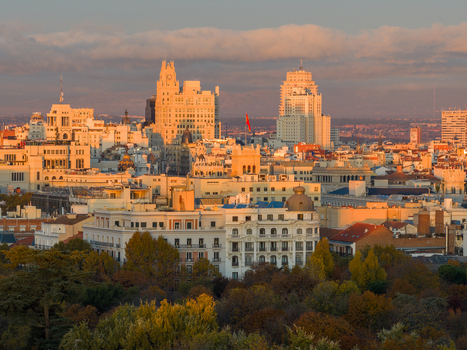 Aerial view of El Retiro Park and the historic skyline of Madrid during golden hour with warm sunlight illuminating the rooftops and architecture Madrid Community of Madrid Spain.