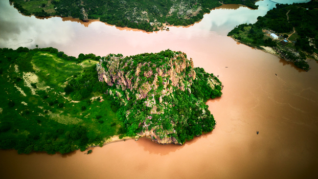 Aerial view of a rocky outcrop surrounded by lush green vegetation in the Niger River near Jebba Niger Nigeria.