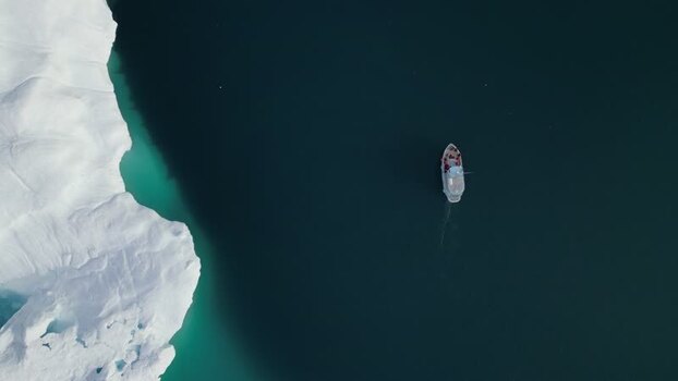 Aerial view of a boat near an iceberg in Ilulissat Greenland. Aerial view of a boat near an iceberg in Ilulissat Greenland.