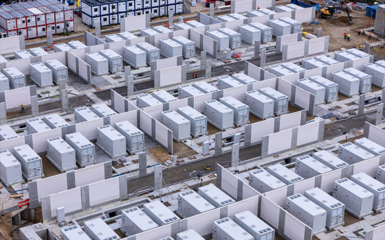 Aerial view of the Zarnowiec Energy Storage facility featuring rows of white battery containers separated by concrete walls at a construction site in Wejherowo County Pomeranian Voivodeship Poland.