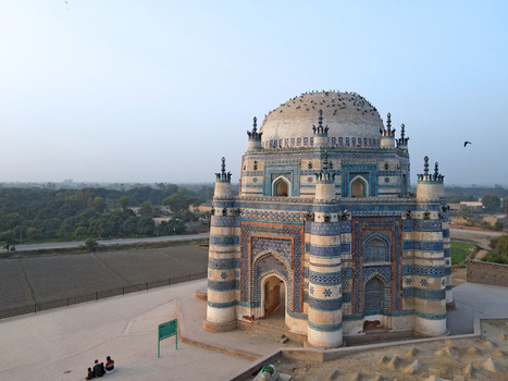 Aerial view of the historic blue tiled tomb with intricate architectural patterns surrounding landscape and people sitting on the ground in Uch Sharif Punjab Pakistan. Aerial view of the historic blue tiled tomb with intricate architectural patterns surrounding landscape and people sitting on the ground in Uch Sharif Punjab Pakistan.