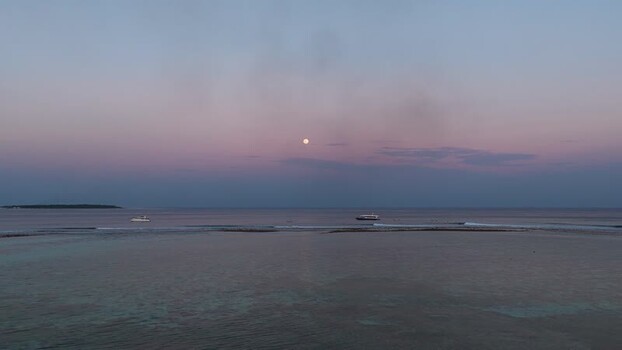 Aerial view of boats on the ocean under a full moon Maldives. Aerial view of boats on the ocean under a full moon Maldives.