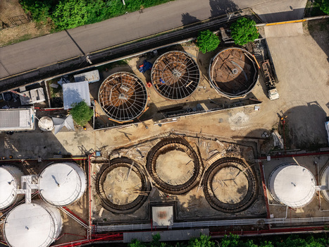Aerial view of an industrial site featuring circular storage tanks and construction foundations with metal reinforcement frames in Bajos de Haina San Cristobal Provinc Dominican Republic.