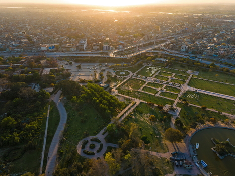 Aerial view of Minar e Pakistan surrounded by lush gardens and pathways at sunset in Lahore Punjab Pakistan.