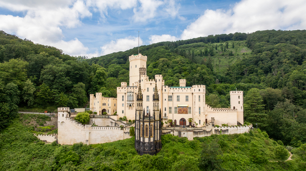 Aerial view of Stolzenfels Castle with its white towers and gothic architecture surrounded by lush green forests under a cloudy sky in Koblenz Rheinland Pfalz Germany. Aerial view of Stolzenfels Castle with its white towers and gothic architecture surrounded by lush green forests under a cloudy sky in Koblenz Rheinland Pfalz Germany.