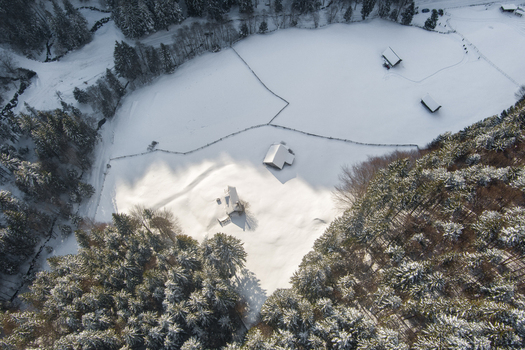 Brasov Brasov Romania 21 September 2026 Aerial view of a snowy landscape with small wooden cabins nestled among dense pine forests and rustic fences under bright winter sunlight. Brasov Brasov Romania 21 September 2026 Aerial view of a snowy landscape with small wooden cabins nestled among dense pine forests and rustic fences under bright winter sunlight.