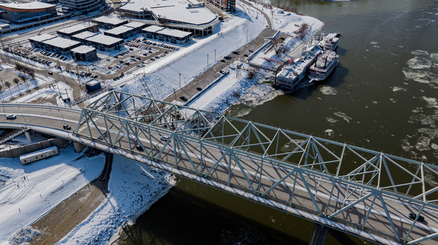 Aerial view of the Taylor Southgate Bridge crossing the Ohio River with ice floes snow covered riverbanks and urban buildings in Cincinnati Ohio United States. Aerial view of the Taylor Southgate Bridge crossing the Ohio River with ice floes snow covered riverbanks and urban buildings in Cincinnati Ohio United States.