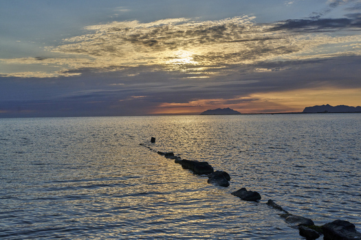 Aerial view of Saline dello Stagnone at sunset with calm waters scattered rocks and a dramatic cloudy sky in Marsala Sicilia Italy. Aerial view of Saline dello Stagnone at sunset with calm waters scattered rocks and a dramatic cloudy sky in Marsala Sicilia Italy.