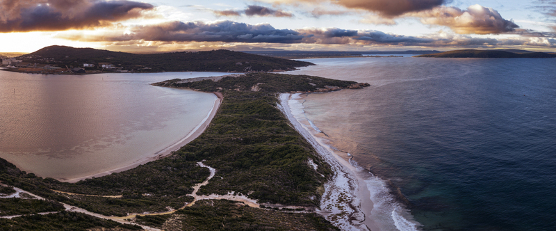 Aerial view of Quaranup Beach with sandy shores dense coastal vegetation and calm waters under a dramatic sunset sky in Vancouver Peninsula Western Australia Australia.