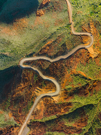 Aerial view of a winding road cutting through a landscape of contrasting earthy tones and verdant vegetation a dance of nature and human design Goro South Province New Caledonia. Aerial view of a winding road cutting through a landscape of contrasting earthy tones and verdant vegetation a dance of nature and human design Goro South Province New Caledonia.
