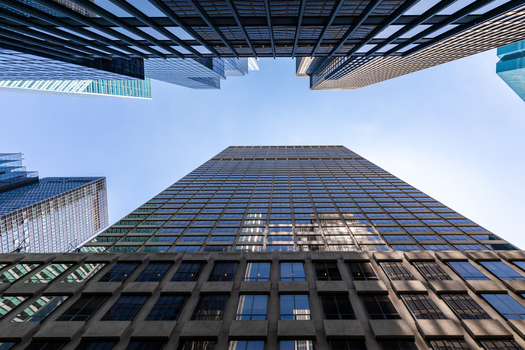 View of modern skyscrapers in a low angle perspective with glass facades reflecting the clear blue sky in New York New York United States. View of modern skyscrapers in a low angle perspective with glass facades reflecting the clear blue sky in New York New York United States.