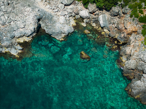 Aerial view of the rugged rocky coastline and crystal clear turquoise waters of Aquarium Beach in Jala Vlore County Albania. Aerial view of the rugged rocky coastline and crystal clear turquoise waters of Aquarium Beach in Jala Vlore County Albania.