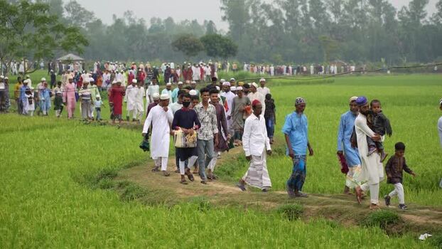 View of a large crowd walking through green fields Bangladesh. View of a large crowd walking through green fields Bangladesh.