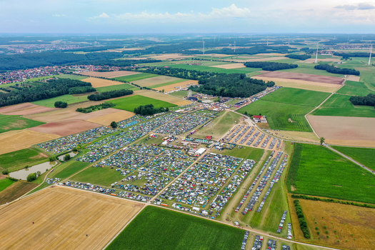 Herzogenaurach Germany 25 July 2025 Aerial view of the Open Beatz Festival featuring a vast camping area parking lots and stages surrounded by green fields and forests. Herzogenaurach Germany 25 July 2025 Aerial view of the Open Beatz Festival featuring a vast camping area parking lots and stages surrounded by green fields and forests.