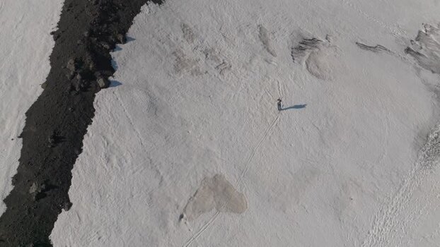 Aerial view of a person walking on the snowy slopes of Mount Etna Italy. Aerial view of a person walking on the snowy slopes of Mount Etna Italy.