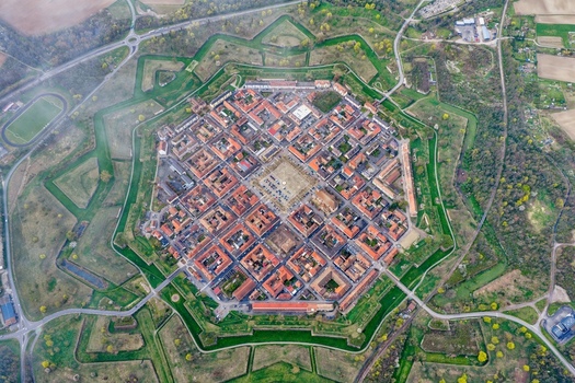 Aerial view of the star shaped fortress city with its red roofed buildings and symmetrical layout surrounded by lush green moats Neuf Brisach Grand Est France.