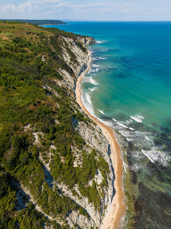 Aerial view of the dramatic white cliffs of Belite Skali covered in lush green vegetation meeting the turquoise waters of the Black Sea in Byala Varna Bulgaria. Aerial view of the dramatic white cliffs of Belite Skali covered in lush green vegetation meeting the turquoise waters of the Black Sea in Byala Varna Bulgaria.