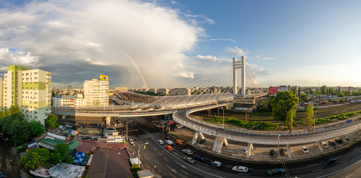 View of the Basarab Overpass with a double rainbow in the sky above the urban landscape railway tracks and traffic in Bucharest Bucharest Romania. View of the Basarab Overpass with a double rainbow in the sky above the urban landscape railway tracks and traffic in Bucharest Bucharest Romania.