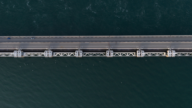 Aerial view of the Eastern Scheldt Storm Surge Barrier with its massive steel gates and road bridge spanning the dark water in Vrouwenpolder Zeeland Netherlands. Aerial view of the Eastern Scheldt Storm Surge Barrier with its massive steel gates and road bridge spanning the dark water in Vrouwenpolder Zeeland Netherlands.