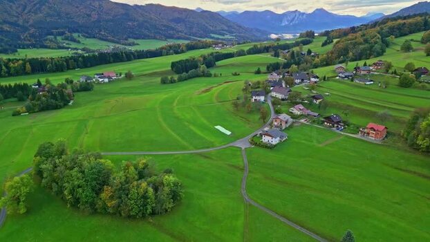 Aerial view of green meadows and rural houses near Attersee Austria.