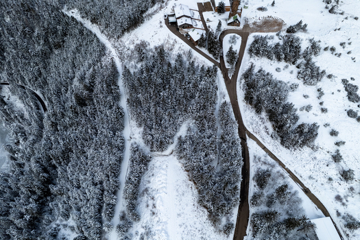 Aerial view of the snow covered Mummelsee area with dense pine forests winding roads and scattered buildings in the winter landscape of Seebach Baden Wurttemberg Germany. Aerial view of the snow covered Mummelsee area with dense pine forests winding roads and scattered buildings in the winter landscape of Seebach Baden Wurttemberg Germany.