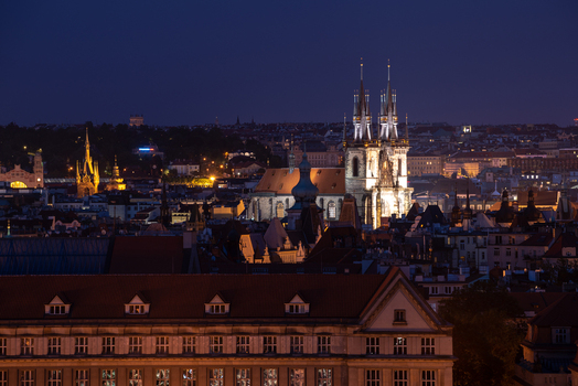 View of the Church of Our Lady before Tyn illuminated at night above the historic rooftops of the city Prague Prague Czechia.