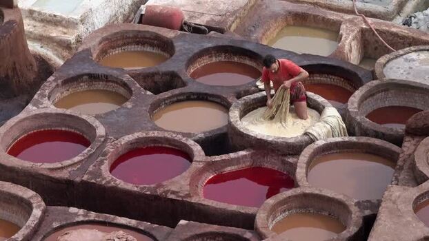 View of a worker dyeing leather at the Chouara Tannery in Morocco.