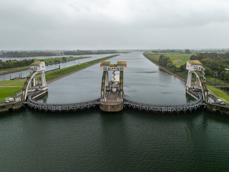 Aerial view of Sluis en stuwcomplex Hagestein on the Lek river featuring concrete weir structures and sluice gates surrounded by green riverbanks in Hagestein Utrecht Netherlands.