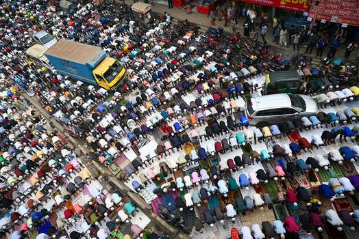 Tongi Bangladesh 31 January 2025 Aerial view of Tongi Ijtema Maidan filled with a large crowd of worshippers performing prayer on mats amidst vehicles and motorcycles in the street.