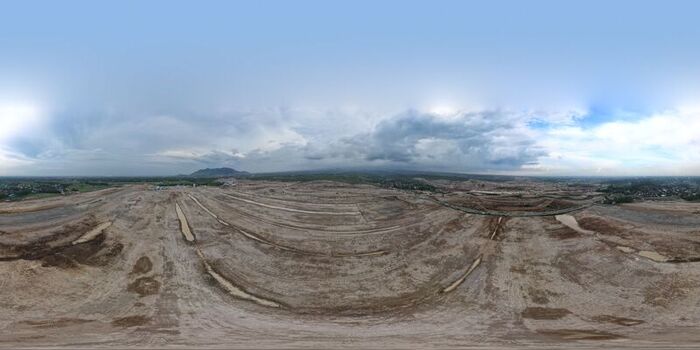 Aerial view of Dhoho International Airport construction site with vast cleared earth tracks and distant mountains under a cloudy sky in Kecamatan Grogol Jawa Timur Indonesia. Aerial view of Dhoho International Airport construction site with vast cleared earth tracks and distant mountains under a cloudy sky in Kecamatan Grogol Jawa Timur Indonesia.