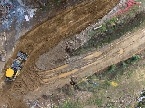 Aerial view of a yellow bulldozer working on a muddy construction site with tire tracks and excavated earth in Istanbul Istanbul Turkiye. Aerial view of a yellow bulldozer working on a muddy construction site with tire tracks and excavated earth in Istanbul Istanbul Turkiye.