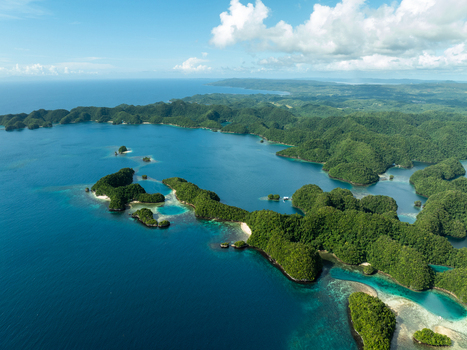 Aerial view of Bucas Grande featuring lush green islands surrounded by turquoise waters and coral reefs under a bright sky in Siargao Philippines. Aerial view of Bucas Grande featuring lush green islands surrounded by turquoise waters and coral reefs under a bright sky in Siargao Philippines.